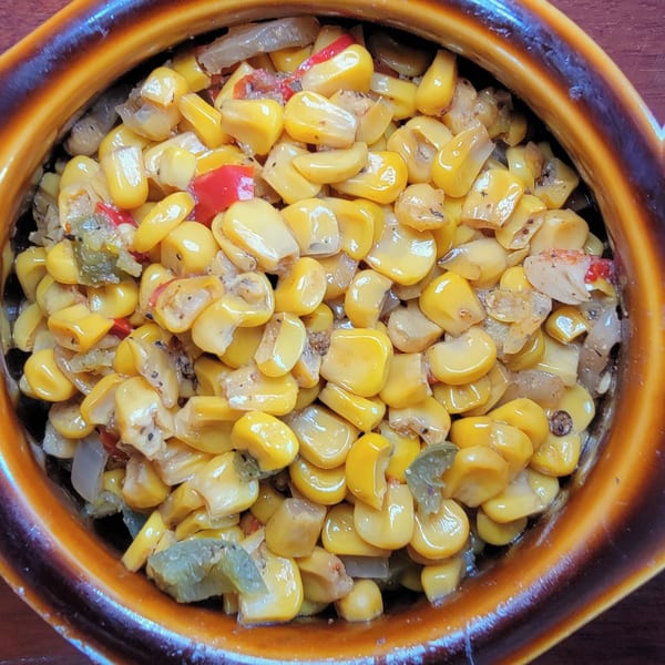 Close-up of a bowl of Santa Maria BBQ's corn, peppers, and onions side dish.